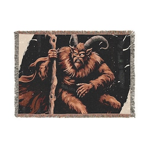 May include: A woven tapestry throw blanket featuring a brown, furry creature with horns and a staff. The creature has a menacing expression and is set against a dark, starry background.