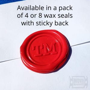 May include: A circular red wax seal featuring the embossed letters TM in the centre. The text above the seal reads Available in a pack of 4 or 8 wax seals with sticky back. The seal has a smooth, glossy finish and a slightly irregular edge.