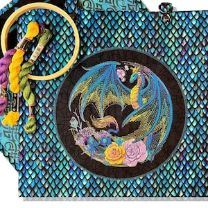 May include: A blue and green fabric tote bag with a circular embroidered design of a dragon with yellow and blue wings and flowers. The bag is made of a fabric with a scale pattern.