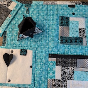 May include: A turquoise and black fabric organizer with multiple pockets and compartments. The organizer has a heart-shaped pocket, a zippered pocket, and a small pouch.