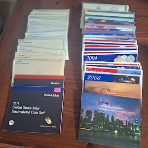 May include: A rustic wooden sign with the text "Welcome" in a handwritten style. The sign is painted white with a distressed finish, and a small, decorative heart is attached. The background is a blurred image of a wooden surface.