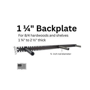 May include: A black metal backplate for shelves, with a 1 1/4 inch height and a 3/4 inch rod diameter. The text reads "1 1/4" Backplate" and "For 8/4 hardwoods and shelves 1 3/4" to 2 1/2" thick". Includes a "Made in USA" flag.