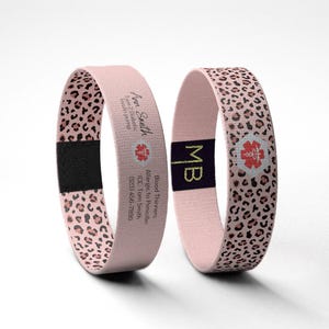 May include: Two pink medical alert bracelets. One bracelet has a leopard print pattern and the other has the text "Ann Smith, Type 2 Diabetic, Insulin pump" and a medical symbol. The second bracelet has the initials "MB" and a medical symbol.
