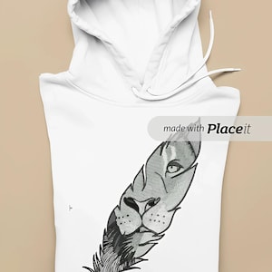 Może przedstawiać: Biała bluza z kapturem z detalicznym wzorem pióra, który zawiera twarz lwa w odcieniach szarości i czerni. Bluza z kapturem ma kaptur ze sznurkiem. Widoczny jest tekst "made with Placeit".