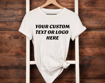 Puede incluir: Camiseta blanca con el texto "YOUR CUSTOM TEXT OR LOGO HERE" impreso en la parte delantera.