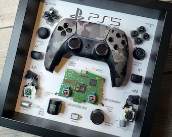 Quadro decorativo com controle de PS5 desmontado – Decoração de parede mimética para gamers com DualSense desmontado.