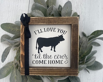 May include: A rustic wooden sign with a black silhouette of a cow and the text "I'll love you 'til the cows come home" with a heart.