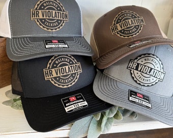 May include: Three black, brown, and gray trucker hats with a white mesh back. Each hat has a brown patch with the text "WALKING HR VIOLATION TALKING" in black and gold lettering.