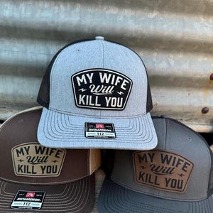 May include: Three trucker hats with the text "MY WIFE WILL KILL YOU" on a patch. The hats are gray, brown, and dark gray, each with a different colored mesh backing. The hats are adjustable.