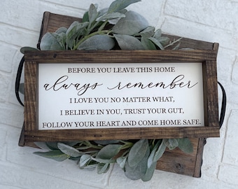 May include: A rectangular wooden sign with a dark brown frame and a white background featuring black text that reads: BEFORE YOU LEAVE THIS HOME always remember I LOVE YOU NO MATTER WHAT, I BELIEVE IN YOU, TRUST YOUR GUT, FOLLOW YOUR HEART AND COME HOME SAFE.