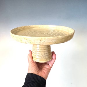 Beautiful handmade ceramic cake stand made with speckled clay and glazed in golden tan with bronze specks.