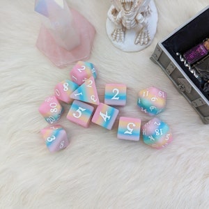 May include: A set of ten colorful dice with rainbow-colored swirls and white numbers. The dice are made of a soft, squishy material.