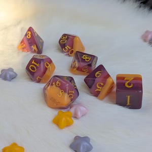 May include: Set of seven dice with a purple and orange swirl pattern. The dice are numbered 1 through 6, 8, 10, and 20.