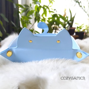 May include: A light blue cat-shaped tray with gold accents. The tray is made of faux leather and has a soft, plush texture.