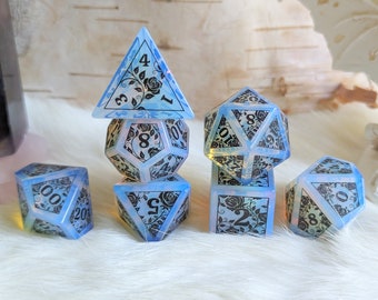 May include: A set of six blue and white dice with black floral designs and black numbers. The dice are arranged in a pyramid shape.
