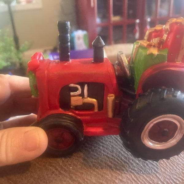 Kleiner roter Traktor, der eine Last von Geschenken schleppt,ausgezeichneter Zustand, neu
