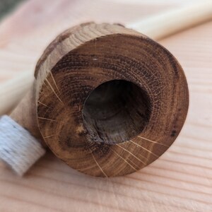 Pu&ograve; includere: Primo piano di una pipa di legno con una finitura marrone naturale. La pipa &egrave; realizzata in un unico pezzo di legno e ha una superficie liscia e lucida. La ciotola della pipa &egrave; rotonda e ha un piccolo foro al centro. Il gambo della pipa &egrave; dritto ed &egrave; attaccato alla ciotola. La pipa &egrave; appoggiata su una superficie di legno.