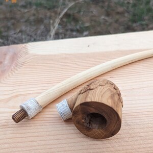 Pu&ograve; includere: Una pipa da fumo in legno con un lungo stelo curvo. La ciotola della pipa &egrave; intagliata con un disegno e ha una corda bianca avvolta attorno. Lo stelo ha anche una corda bianca avvolta attorno.