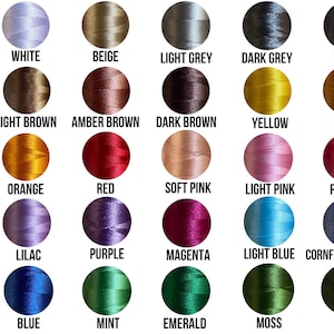 May include: A chart of 20 different thread colors for embroidery, including white, beige, light grey, dark grey, black, light brown, amber brown, dark brown, yellow, gold, orange, red, soft pink, light pink, fuchsia, lilac, purple, magenta, light blue, cornflower blue, blue, mint, emerald, moss, and olive.