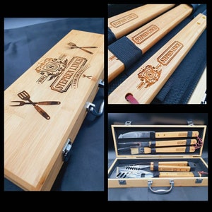 Può includere: Una scatola di legno con maniglia e chiusura, incisa con il testo "BBQ. Stephen Lynch. Premium Quality." La scatola contiene un set di utensili per grigliare con manici in legno, tra cui una spatola, pinze e un pennello.