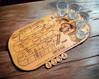 May include: A wooden game board with a snakes and ladders design. The board is engraved with the words "Shots & Ladders" and "How to Play". There are five shot glasses on the board, and the numbers 1, 2, 3, and 4 are visible.