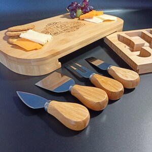 May include: A bamboo cheese board with a personalized inscription, "Celebrating 25 Years Mr. & Mrs. Roberts", and a set of four cheese knives with wooden handles. The board has a removable section for serving crackers and cheese.