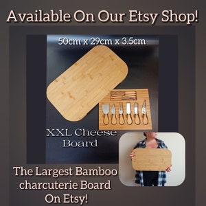 May include: A large rectangular bamboo cheese board with a lid and a set of cheese knives. The board measures 50cm x 29cm x 3.5cm. The text "XXL Cheese Board" is printed on the board. The text "The Largest Bamboo charcuterie Board On Etsy!" is printed below the board.
