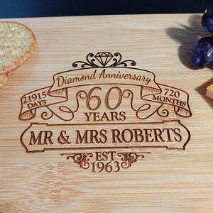 May include: A wooden cutting board with a diamond anniversary inscription. The inscription reads "Diamond Anniversary 60 Years Mr. & Mrs. Roberts Est. 1963" with a diamond graphic and ribbon banners.