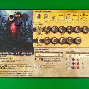 May include: A board game card with the text "BRINGER OF DREAMS AND NIGHTMARES" and special rules. The card features illustrations, tokens, and game mechanics. The color scheme includes shades of brown, gold, and black, with a green background.