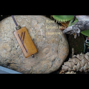 Peut inclure: Un pendentif en bois avec la rune Fehu gravée dessus. Le pendentif est brun et a un cordon en cuir. Le texte "Rune FEHU Coloris bois (marron)" est visible sur l'image.