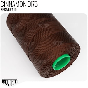 May include: A spool of brown waxed thread with a green plastic end cap. The label on the spool reads "CINNAMON 0175 SERABRAID".