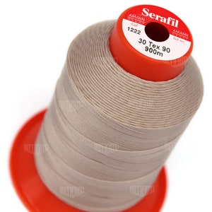 May include: A spool of beige thread labeled "Serafil" with the brand name "Amann Group" and the text "Col 1222 30 Tex 90 900m".