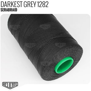 May include: A spool of black thread with a green end cap. The label reads "DARKEST GREY 1282 SERABRAID".