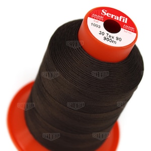 May include: A spool of brown thread labeled "Serafil" with the brand name "Amann Group" and the text "Col 1003 30 Tex 90 900m".