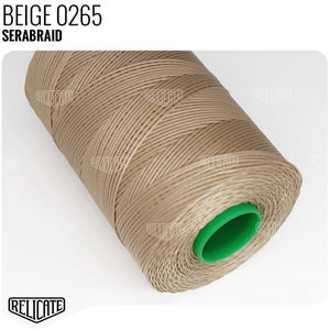 May include: A spool of beige thread labeled "BEIGE 0265 SERABRAID" with a green plastic center.