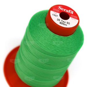 May include: A spool of green thread labeled "Serafil" with the text "Amann Group", "Col 1427", "30 Tex 90", and "900m".