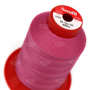 May include: A spool of pink thread labeled "Serafil 30 Tex 90 900m" by Amann Group.