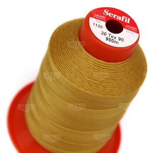 May include: A spool of gold thread labeled "Serafil" by Amann Group. The spool is 900 meters long and is a 30 Tex 90 thread. The spool is labeled with the color number 1130.