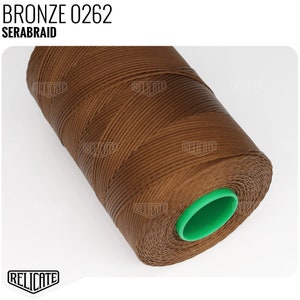 May include: A spool of brown waxed thread with a green plastic end cap. The label on the spool reads "SERABRAID BRONZE 0262".