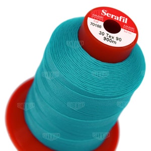 May include: A spool of turquoise blue Serafil thread by Amann Group. The spool is labeled with the color number 70188, 30 Tex 90, and 900m.