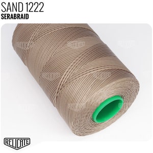 May include: A spool of sand-colored thread, labeled "SAND 1222 SERABRAID", is wound around a green plastic core.