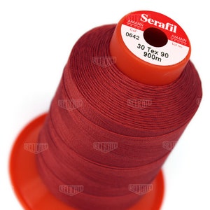 May include: A spool of red thread labeled "Serafil" with the brand name "Amann Group" and the details "Col 0642", "30 Tex 90", and "900m".