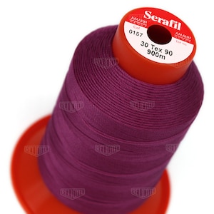 May include: A spool of purple thread labelled "Serafil" with the text "30 Tex 90 900m" and "Col 0157" on the label.