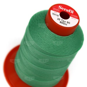 May include: A spool of green thread labeled "Serafil" with the brand name "Amann Group" and the text "Col 70118 30 Tex 90 900m".