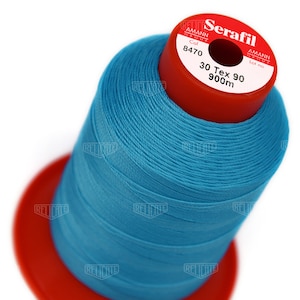 May include: A spool of blue thread labeled "Serafil" with the brand name "Amann Group" and the color number "8470". The spool is labeled "30 Tex 90 900m".