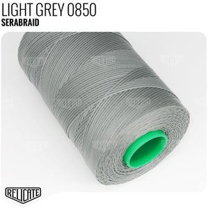 May include: A spool of light grey thread labeled "LIGHT GREY 0850 SERABRAID". The thread is wound around a green plastic spool.