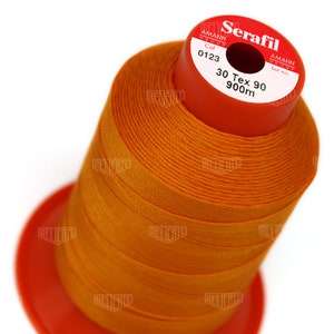 May include: A spool of orange thread labeled "Serafil" with the brand name "Amann Group" and the details "Col 0123", "30 Tex 90", and "900m".