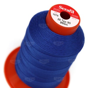 May include: A spool of blue thread labeled "Serafil" with the brand name "Amann Group" and the details "Col 1078 30 Tex 90 900m".