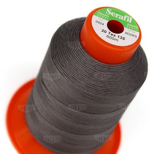Może przedstawiać: Szpula szarej nici z etykietą "Serafil" z tekstem "20 Tex 135 600m" i "Col. 0324 Lot no. 9D2RS".