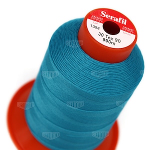 May include: A spool of turquoise blue thread labeled "Serafil" with the brand name "Amann Group" and the details "Col 1394", "30 Tex 90", and "900m".